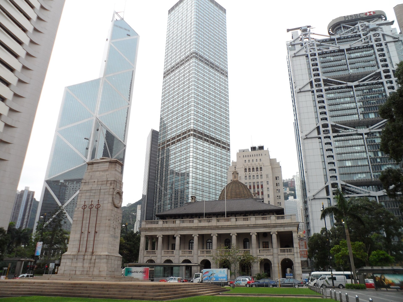 香港立法会大楼外景，浅色石材立面与门前树木，作为跨境收入与税务申报公共办事场景的真实城市背景。