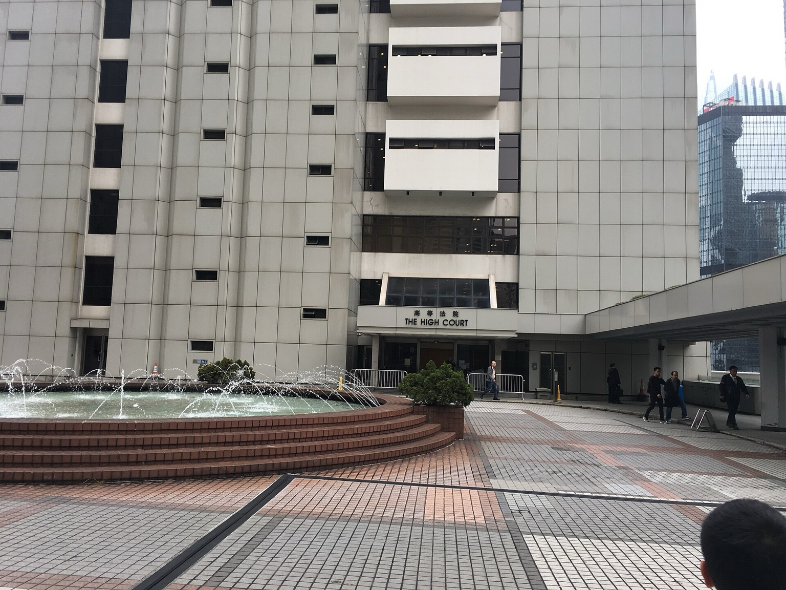 香港高等法院正门外景，入口台阶、石材立面和前方道路构成清晰的真实法律公共建筑环境。