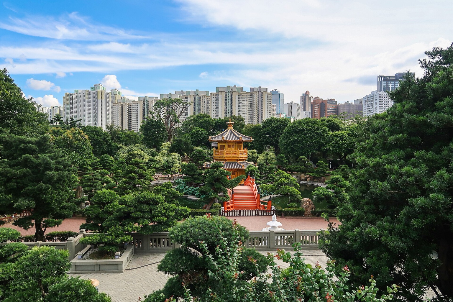 香港南蓮園池的园林实景，传统亭台、池塘与修剪整齐的树木构成安静景观。