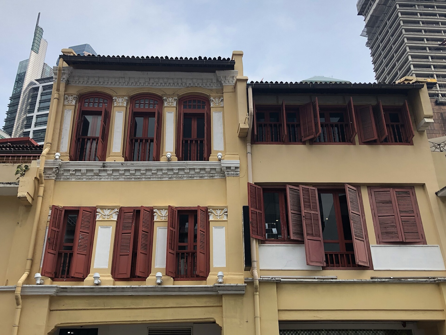 新加坡中国街的真实街景，低层历史建筑与城市道路在日光下连续展开。